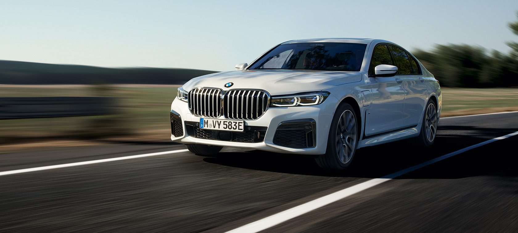 BMW 7 Series Sedan plug-in hybrid G11 G12 three-quarter front view driving BMW 7 Series Sedan plug-in hybrid G11 G12 three-quarter front view driving on the street