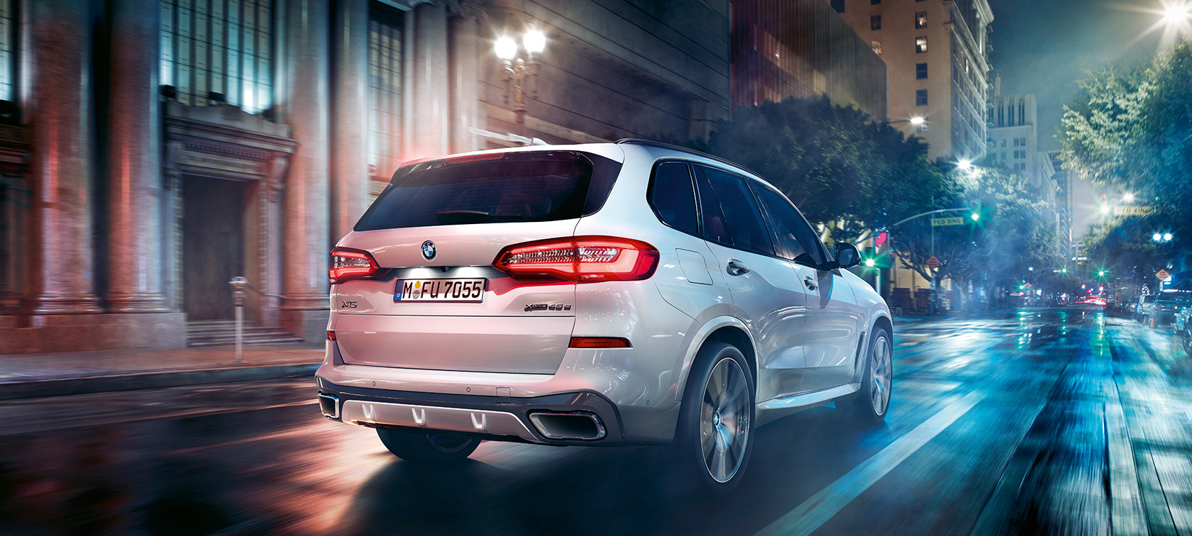 BMW X5 three-quarter rear view driving BMW X5 G05 2018 Mineral White metallic three-quarter rear view driving